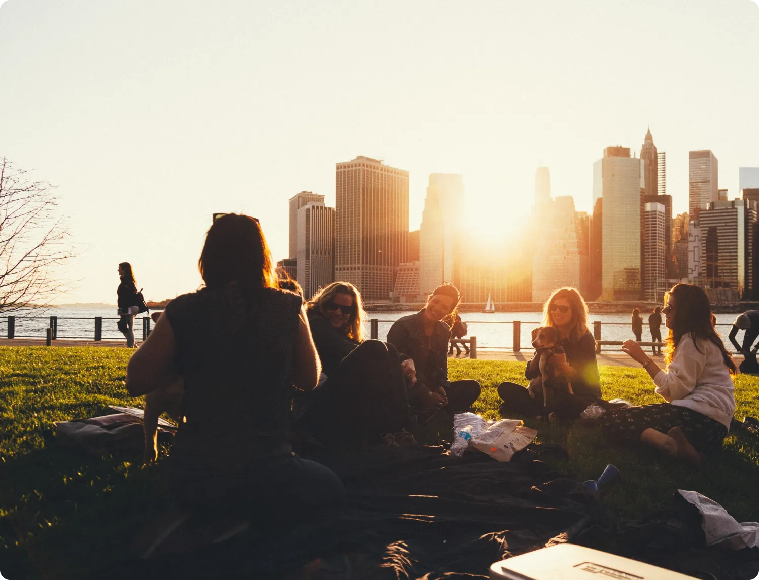 Happy people enjoying the park with city skyline in the background.